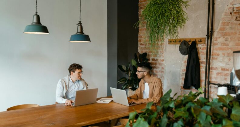 woman in white long sleeve shirt sitting on chair in front of macbook